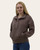 Woman wearing brown quilted pullover, angled front view with partially open snap-button collar and hand in pocket.