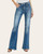 Styled front view of flare jeans with model's hands in pockets, showing stretch fit and distressed hem. Styled front view of flare jeans with model's hands in pockets, showing stretch fit and distressed hem.