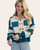 Front view of model wearing a striped pullover with oversized grommet details and cuffed sleeves.