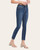 Angled left view of medium wash high-rise skinny jeans styled with a white crop top and nude heels.