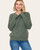 Woman wearing dark sage sweater with crew neckline and relaxed fit