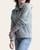 Side angle of the women's aqua grey quilted pullover highlighting the snap button collar and ribbed cuff details.