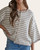 Front angle of the Georgi striped knit sweater styled half-tucked into denim.