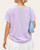 Back view of the 100% cotton lilac PRAY graphic t-shirt styled with rolled sleeves, perfect for a sunny South Dakota spring day.