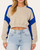 Front view of the contrast edge cropped sweatshirt in tan and cobalt blue styled with high-waisted light wash denim.