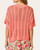 Back view of the loose knit coral crochet dolman sweater featuring a banded hem.