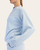 Side view of the light blue relaxed fit Scuba Luxe pullover sweater.