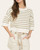 Front view of a woman wearing the Casey striped sweater in olive green and cream, styling a casual spring outfit.