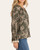 Side view of the Freya Floral Print Blouse highlighting the long elastic ruffled sleeves and delicate lace details.