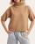 Front view of the camel short sleeve turtleneck sweater with a boxy bodice, styled casually for late summer.