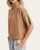 Side profile of the camel short sleeve turtleneck sweater showcasing the drop shoulder design and ribbed cuff details.