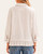 Back view of a woman modeling a striped blouse with unique seam details and a ruffled hem.
