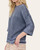 Side profile of a model wearing the washed navy short sleeve sweatshirt featuring a side slit hem and oversized drop-shoulder fit.