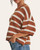 Close up of the Weekend In Cannes Striped Sweater in chestnut and cream, highlighting the 1/2 length sleeves and crew neckline.