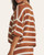 Woman modeling the Weekend In Cannes Striped Sweater in chestnut and cream from a side angle, showing the drop shoulder and boxy fit.