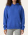 Woman modeling the cozy front kangaroo pocket of the LIV Outdoor Hayden Oversized Hoodie in cobalt