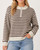 Woman wearing a lightweight brown and cream striped half-zip sweater with drop shoulders and a mock neck, pairing it with blue jeans for unpredictable South Dakota autumn weather.