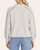 Back view of the light grey Democracy Bubble Hem Knit Top showing contrast piping details on the sleeves.