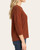 Side profile showing the 3/4 sleeves and relaxed drape of the Democracy grid stitch sweater.