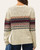 Back view of model wearing the oatmeal speckled Devon Fair Isle Sweater with denim blue and burgundy pattern across the upper back.   
