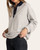 Angled front view of the Thread & Supply Crest Pullover - Heather Grey, with the model holding out the hem.