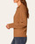 Side view of the brown Democracy Crochet Scalloped Collar Sweater with a fold-over collar, textured sleeve and ribbed cuff.
