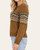 Side view of the Devon Fair Isle Sweater - Pumpkin/Olive on a model, showing upper-sleeve patterning and a ribbed cuff.