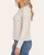 Side view of the cream Leaf Print Long Sleeve Top on a model, showing lightly ribbed fabric and long sleeves.