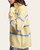 Side view of the Maria Mock Neck Sweater - Lemon/Sky on a model, showing the raised collar, drop shoulder and striped sleeve.