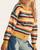 Angled front view of the On The Horizon Soft Knit Cardigan, showing the button closure, drop shoulders and striped sleeves.