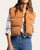 Issey Vest - Leather Brown worn open over a cream and navy plaid shirt, showing the cropped hem, stand collar and zip front.