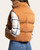 Angled back view of the Issey Vest - Leather Brown, showing the stand collar, horizontal quilted panels and cropped length.