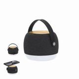 A black and white portable speaker with a wooden top and a black handle. It features a logo. A black and white portable speaker with a wooden top and a black handle. It features a logo.