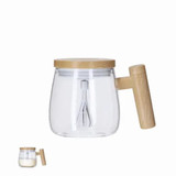 A glass mixing cup with a wooden handle and a lid, featuring a whisk inside. The glass is clear and the handle is light brown. A glass mixing cup with a wooden handle and a lid, featuring a whisk inside. The glass is clear and the handle is light brown.
