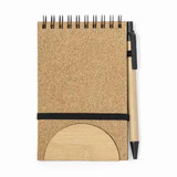 A cork-covered notebook with a bamboo base and black pen attached, featuring a spiral binding.