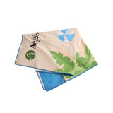 A microfibre beach towel featuring a vibrant design of leaves and shapes, with blue trim and a logo.