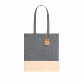 A tote bag in grey recycled cotton with a cream bottom section and a label attached. Features a logo.