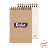 A recycled paper notepad with a spiral binding, featuring a brown cover and lined pages, along with a logo.