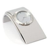 A sleek silver desk clock with a modern design and a circular face. It features a reflective finish and has a logo.