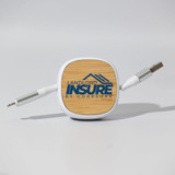 A square cable organiser with a wooden top and two grey charging cables extending from it.