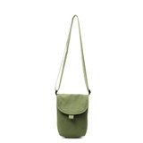 A small size canvas shoulder bag in a muted green colour with an adjustable strap and a flap closure.