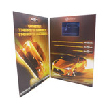 A promotional product with a glossy, orange design featuring a Toyota 86, open to display images and a screen. It has a logo.
