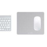 A silver alumina mouse pad with a glossy white surface positioned next to a light grey keyboard.
