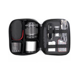 A black storage case containing a camera lens, batteries, cables, and a multi-tool, neatly organised.