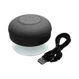 A waterproof Bluetooth speaker in black with a suction base and a USB charging cable.