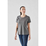 A woman wearing a grey short sleeve performance tee, featuring a rounded neckline and a slightly relaxed fit.