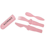 A pink cutlery set made from wheat straw, including a knife, fork, and spoon, accompanied by a rectangular holder.