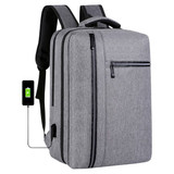 A grey laptop backpack with multiple compartments, featuring a USB charging port and a logo.