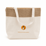 A jute and cotton cooler bag in cream and tan with a logo on the front, featuring sturdy handles.