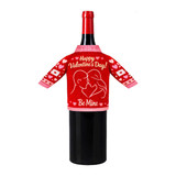 A drink bottle dressed in a red and pink knitted sleeve with a couple silhouette and heart motifs.